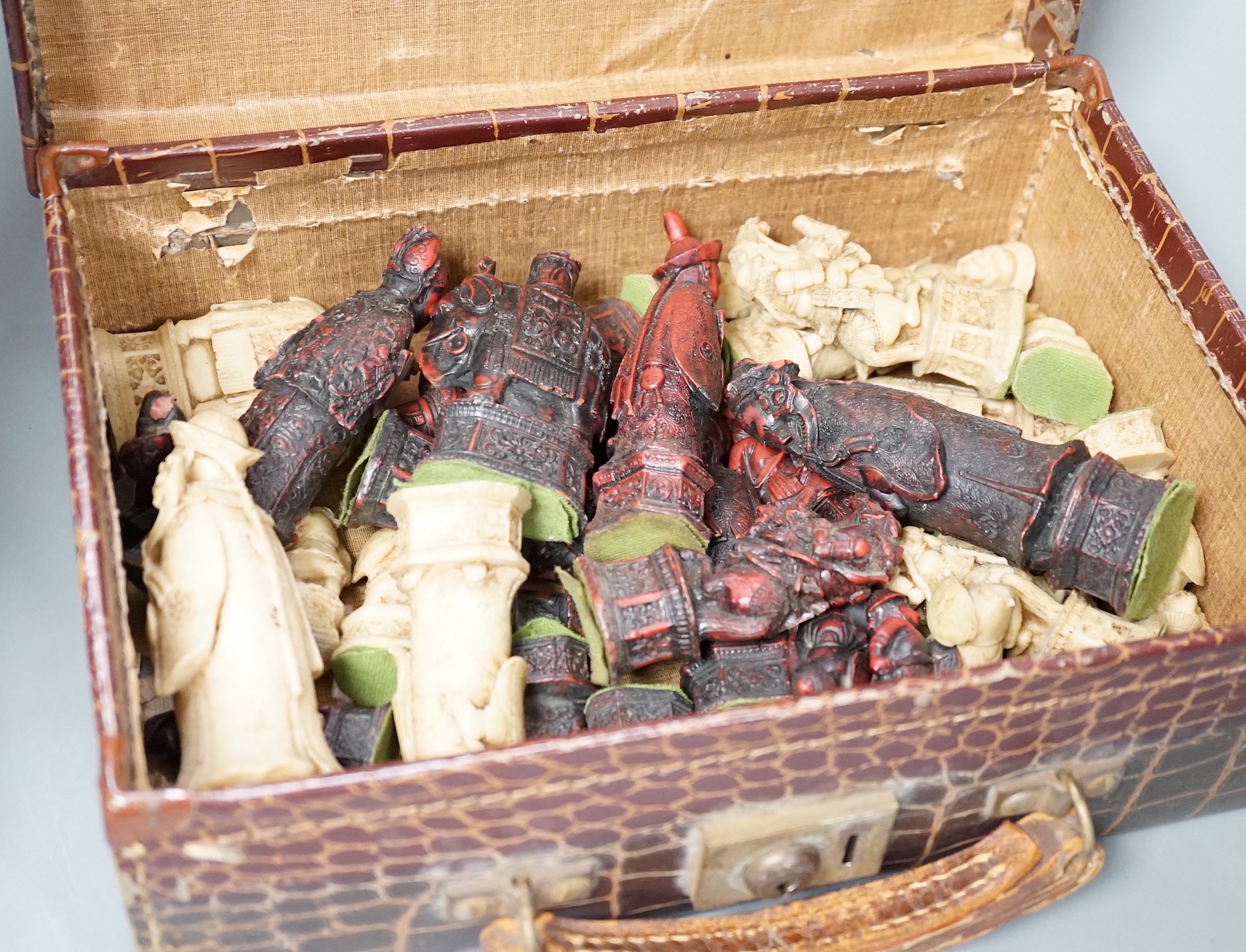 A moulded resin chess set in faux crocodile suitcase